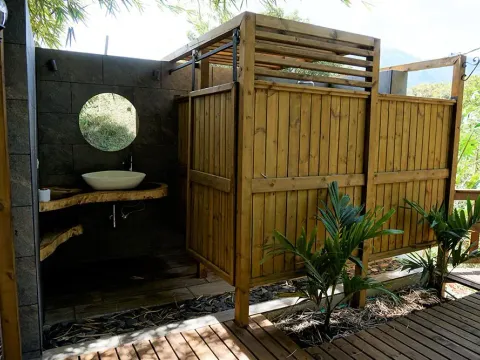 Baño exterior con cerramiento de madera y lavamanos, obra con maderas de Madepinos