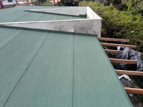Cubierta impermeabilizada con manto asfáltico verde en una vivienda de Antioquia