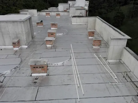 Terraza de edificio impermeabilizada con manto asfáltico gris, obra de Madepinos