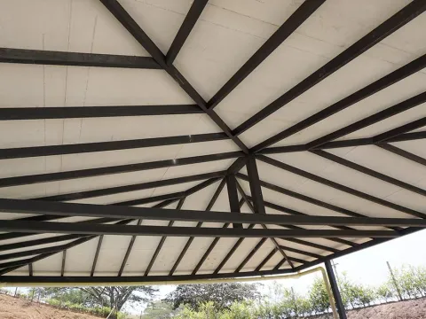 Cubierta interior con vigas de madera en forma de abanico, obra con materiales Madepinos