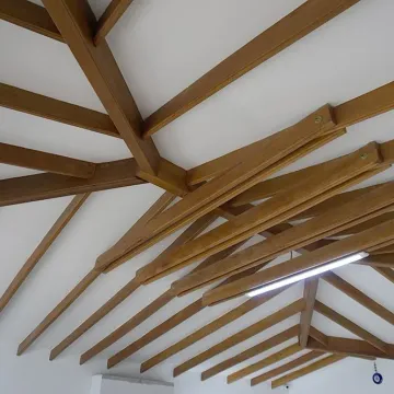 Techo con vigas de madera vistas sobre cielo raso blanco, obra con materiales Madepinos