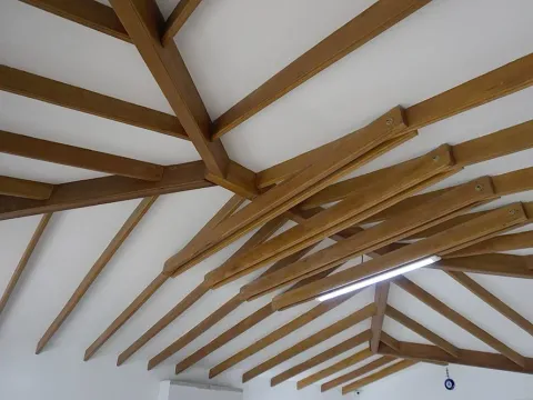 Techo con vigas de madera vistas sobre cielo raso blanco, obra con materiales Madepinos