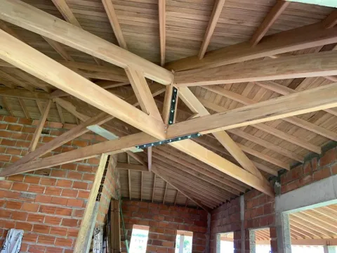Estructura de techo de madera con cerchas y ladrillo a la vista en Antioquia