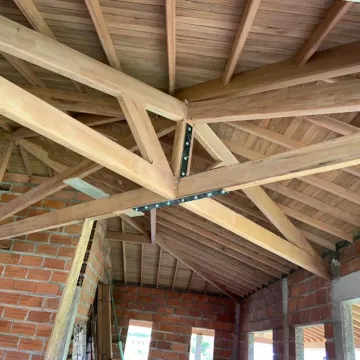 Estructura de techo de madera con cerchas y ladrillo a la vista en Antioquia