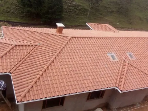 Casa grande con techo de teja de barro y estructura de madera en Antioquia