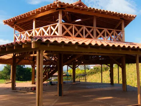 Kiosco de dos pisos en madera con techo de teja de barro, obra Madepinos