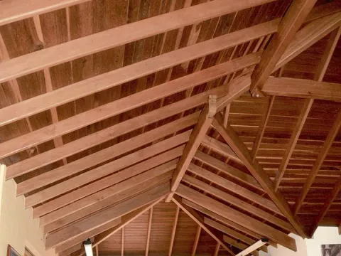 Cubierta interior en madera con vigas y tablilla, obra construida en Medellín por Madepinos