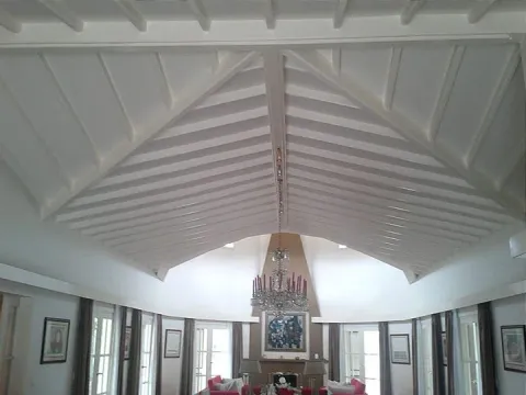 Techo interior con vigas de madera pintadas de blanco, obra con materiales Madepinos