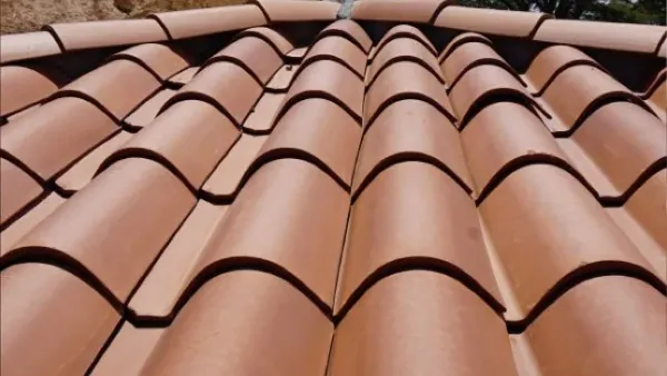 Techo de casa con teja de barro bogotana color rojo instalada sobre estructura de madera